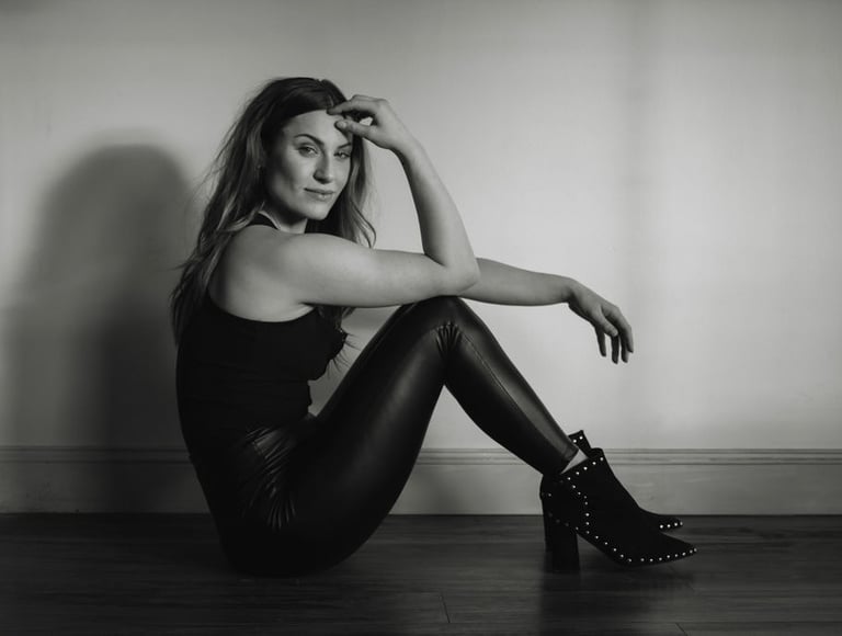 a woman in black and white photo of a woman in leather pants and boots