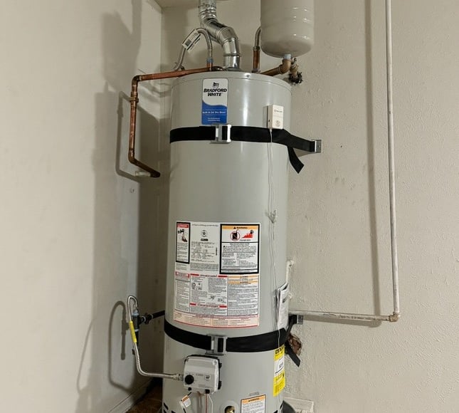 A Bradford White natural gas water heater installed with seismic straps and an expansion tank.