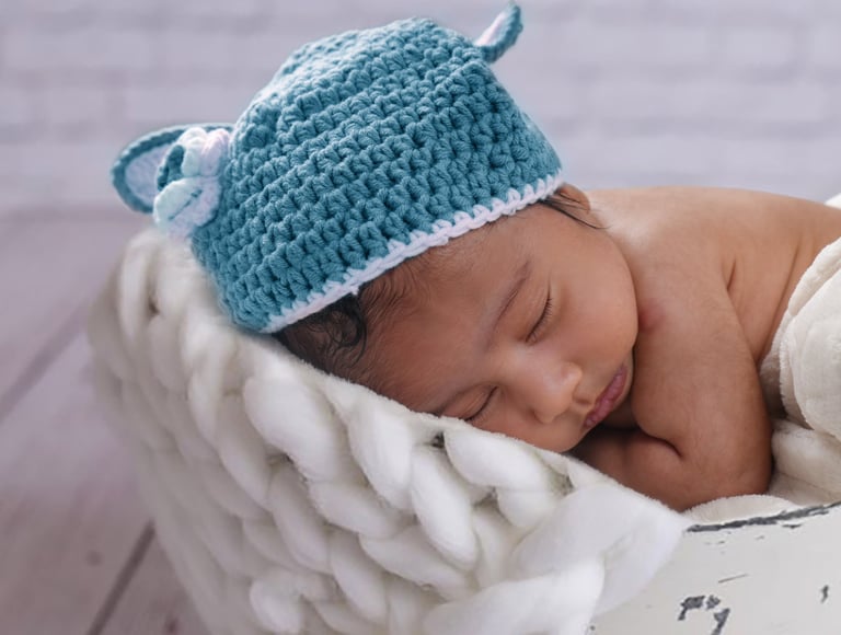 Adorable newborn baby peacefully sleeping in a cozy wrap at Pixel Craft Digital Studio.