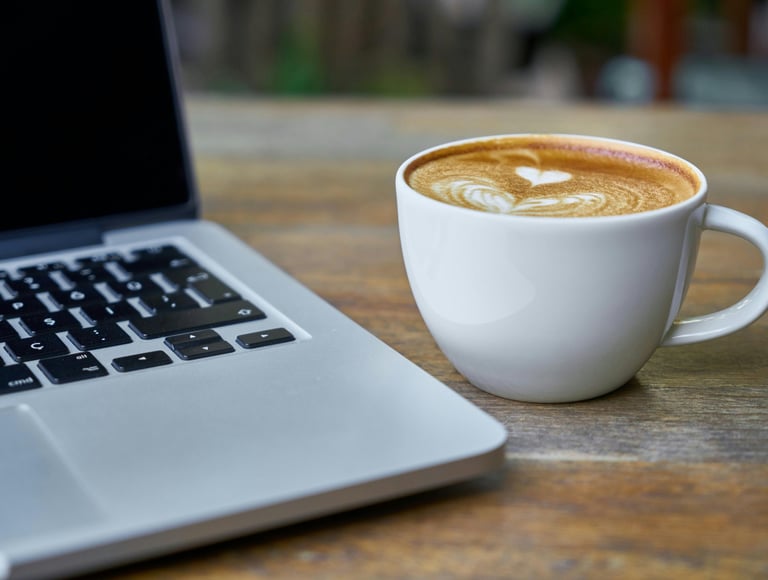 Laptop en cappuccino voor een online kennismakingsgesprek van schoolleider met Praktisch Met Lef.