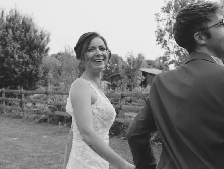 Mariés se tenant la main dans un jardin lors de leur séance vidéo de mariage