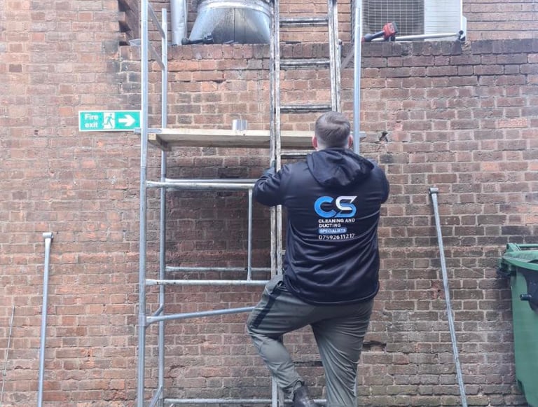 a man in cs cleaning and ducting company workwear fixing ducting