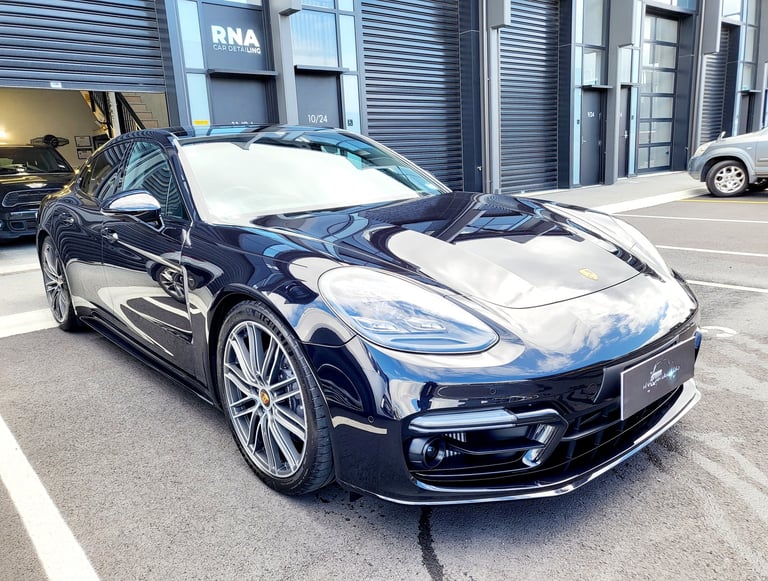 Paint corrected and ceramic coated black Porsche Panamera parked outside The Coating Lab Auckland