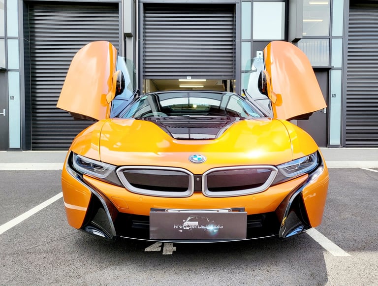 Front view of an orange BMW i8 hybrid sports car with butterfly doors open by The Coating Lab