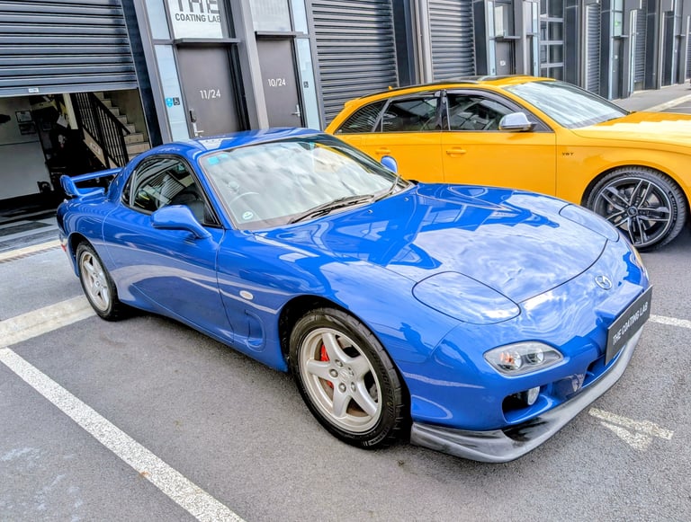 A blue Mazda RX-7 FD sports car parked outside The Coating Lab ceramic coating detailing studio
