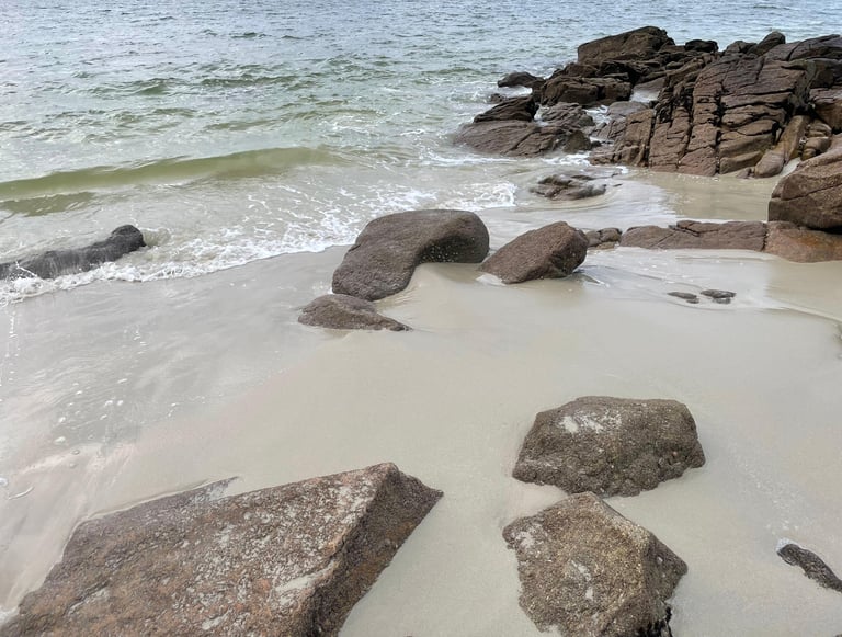 plage de sable avec des rochers et la mer