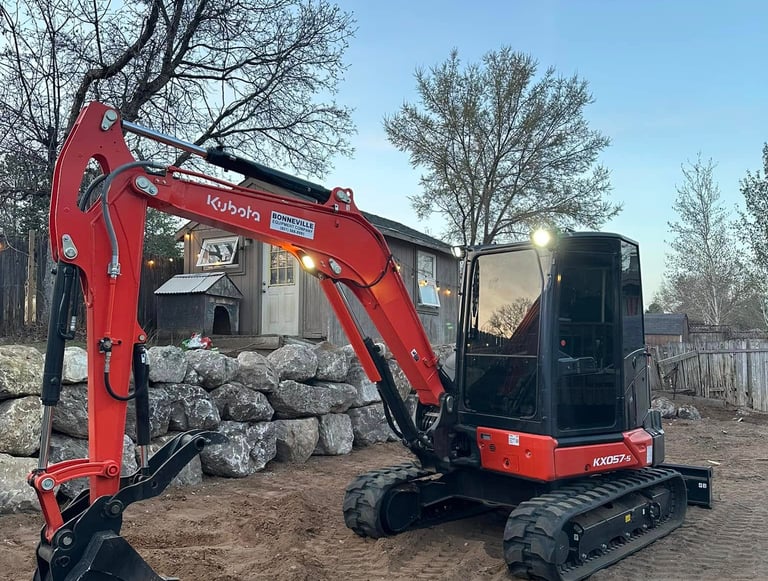 Kubota sitting idle next to completed boulder wall in Ogden, UT