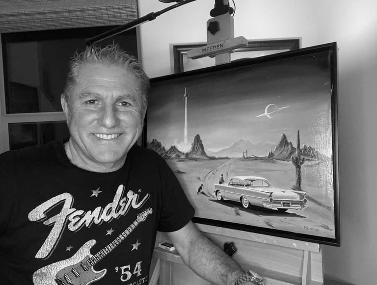 A black and white photograph of Marc Lee in front of his easel