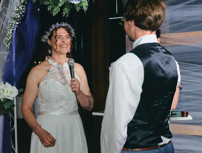 a bride holding a microphone giving a speech to the groom