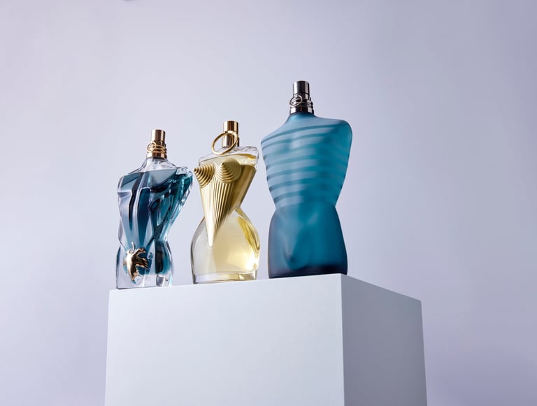 Product Photography of sculptural fragrance bottles on a minimalist pedestal, capturing luxury glass