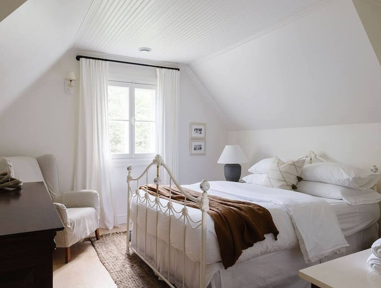 Une chambre avec un lit, une lampe et un cadre artistique