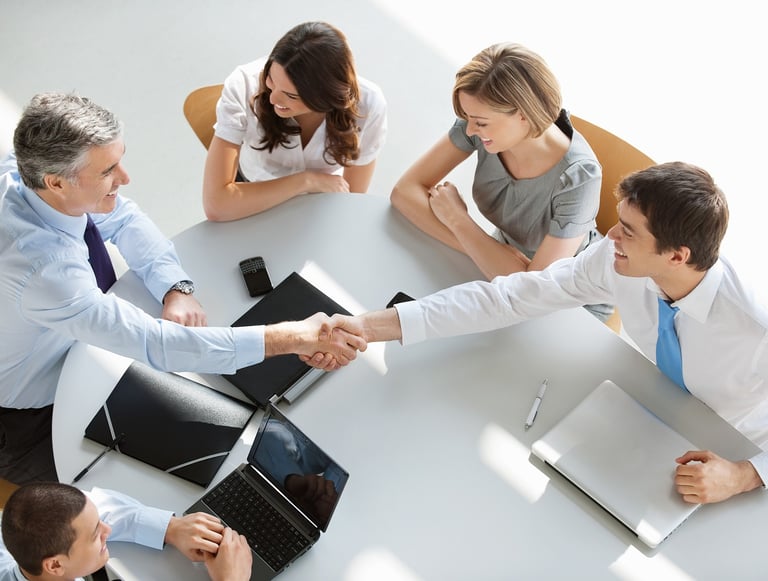 a group of business people shaking hands