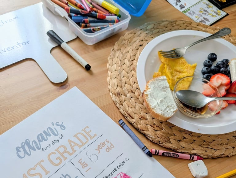 homeschool day with breakfast on table alongside crayon box and school stuff
