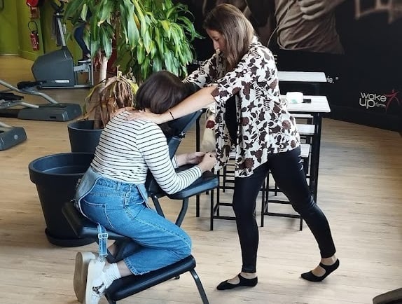 Un massage assis sur une personne détendue, installée sur une chaise ergonomiqu
