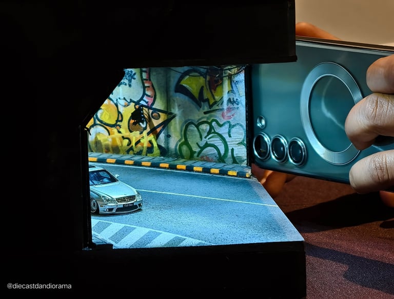 a person taking a picture of a 1/64 model car in a picture