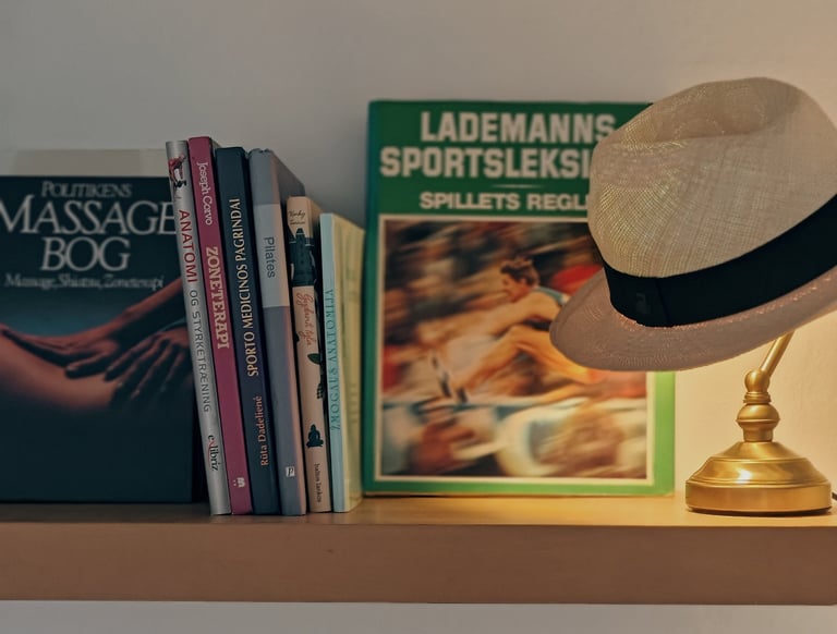a hat on a shelf with books and a lemp