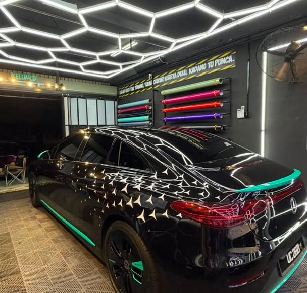 Mercedes sedan with custom black star pattern and teal accent wrap