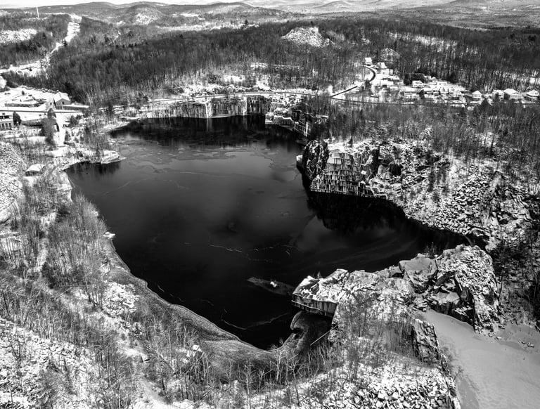 Black & white image of the Rock of Ages granite quarry in Barre, VT during the winter