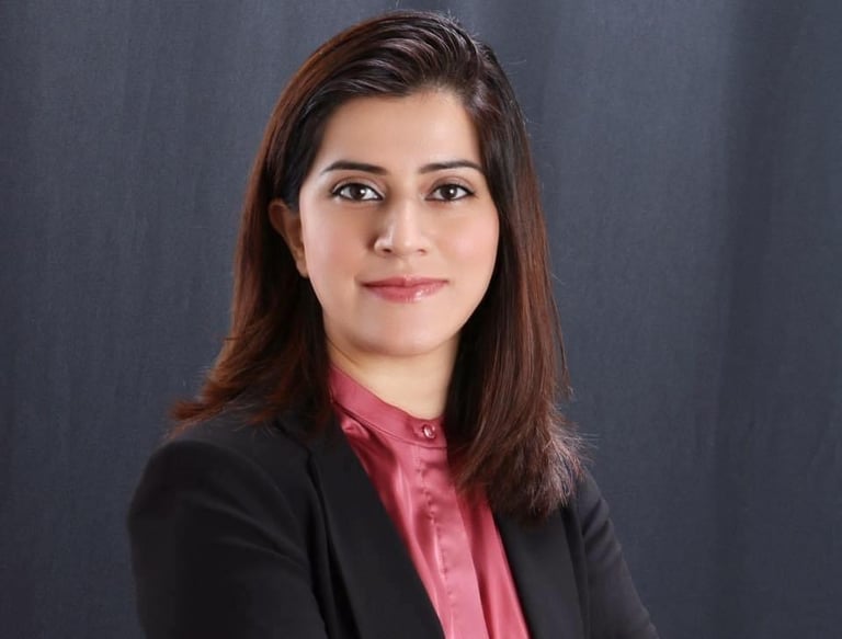 a woman in a black suit and pink shirt