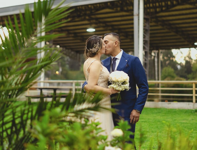 Fotografía de bodas en Quito, Ecuador, pareja de recién casados dándose un beso en un paisaje verde