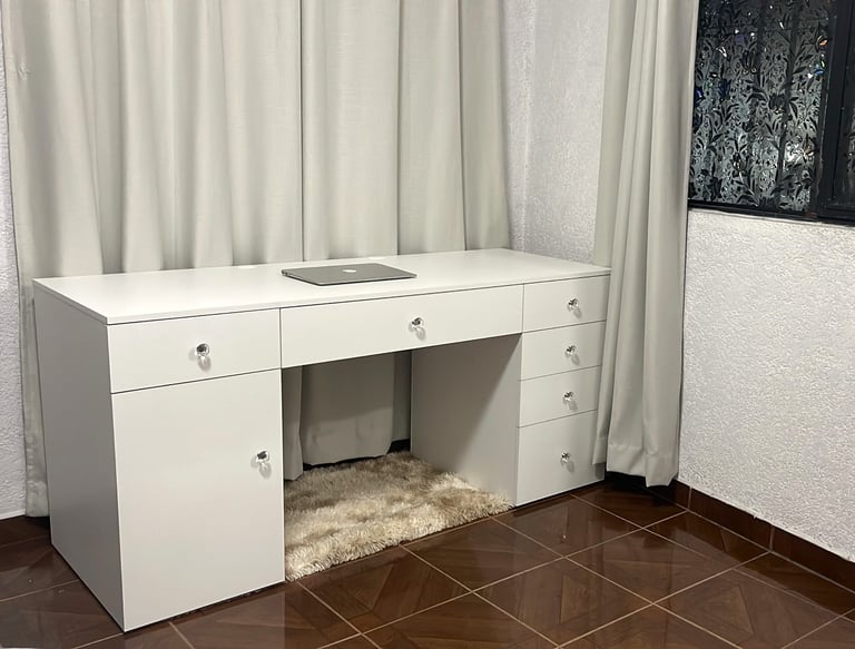 a desk with a computer desk and a laptop