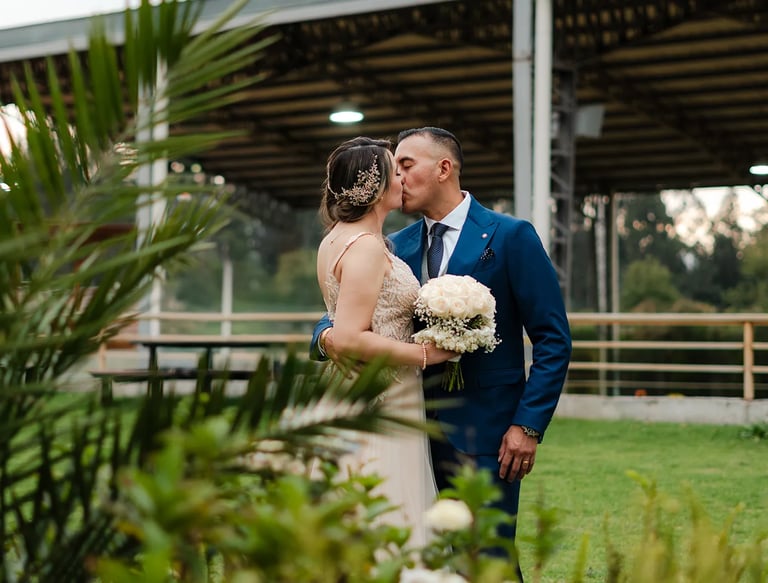 Fotografía de bodas en Quito, Ecuador, pareja de recién casados dándose un beso en un paisaje verde