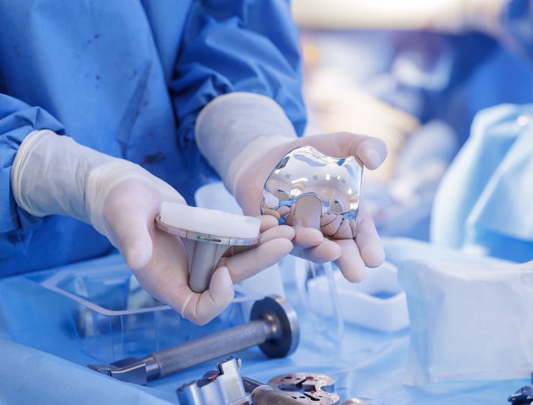 medical technical inspecting a set of orthopedic knee implants.