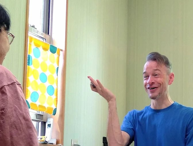 man sitting at table teaching student