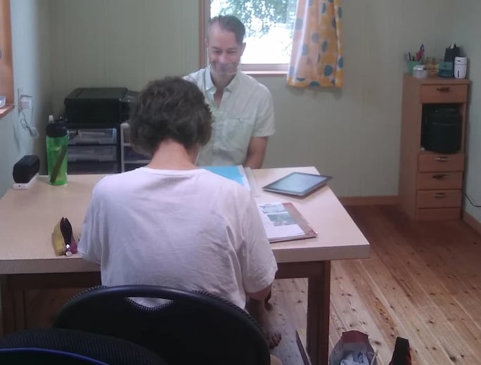 man teaching student at table