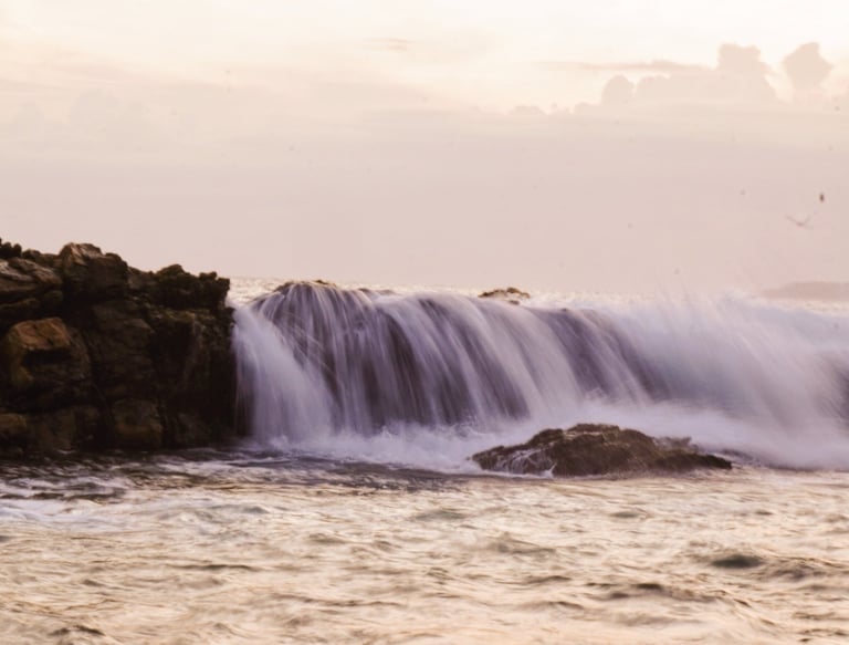 water falling down rocks in the sea into rock pool