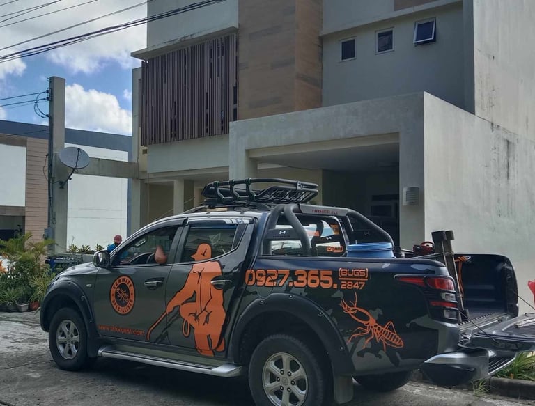 Professional termite control service truck parked in front of a modern residential home.