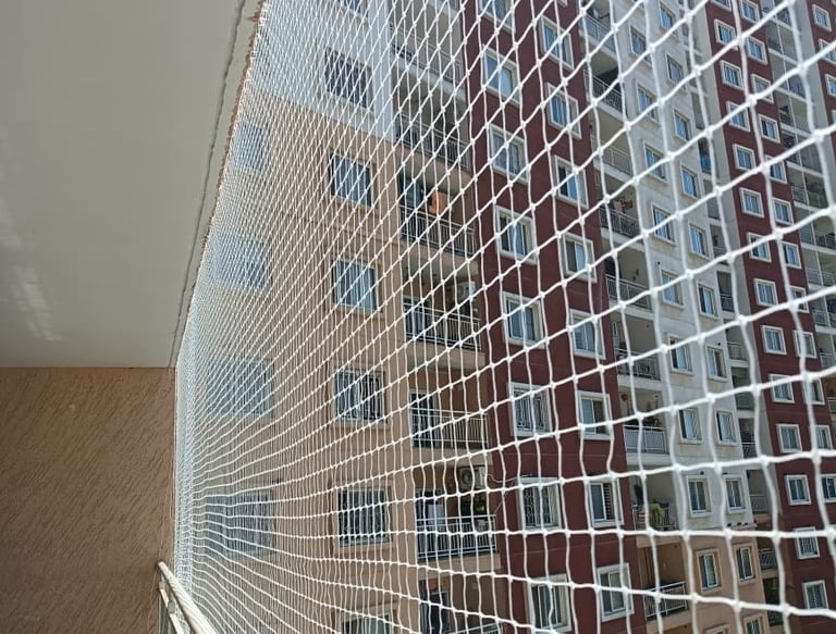 Close-up of a sturdy pigeon net securely installed on a balcony in Jalahalli.