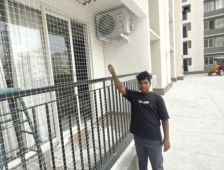 A happy family enjoying their balcony safely enclosed with Arjilli Safety Nets under a bright sky.