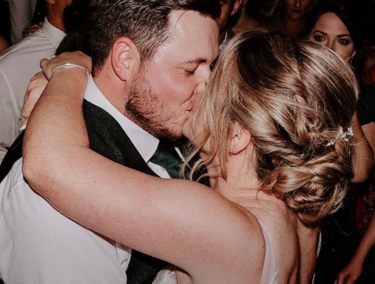 a bride and groom kissing on the dance floor