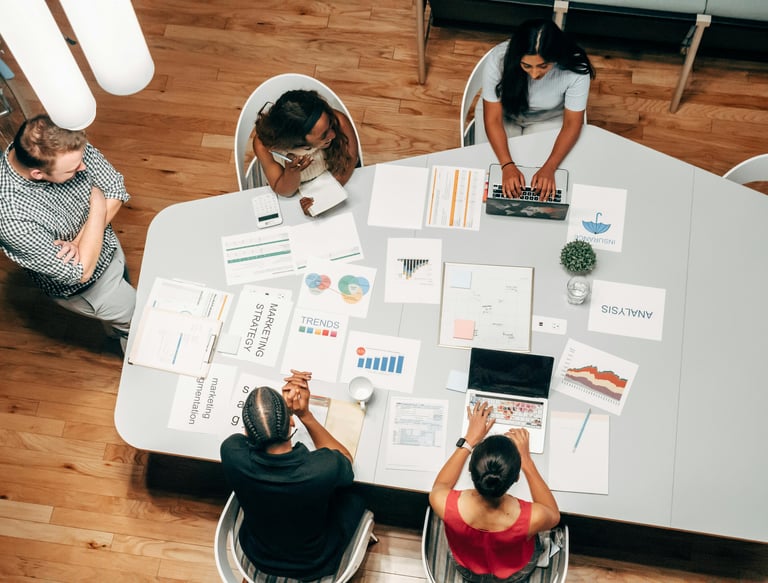 Equipo trabajando en oficina, con portátiles y gráficos