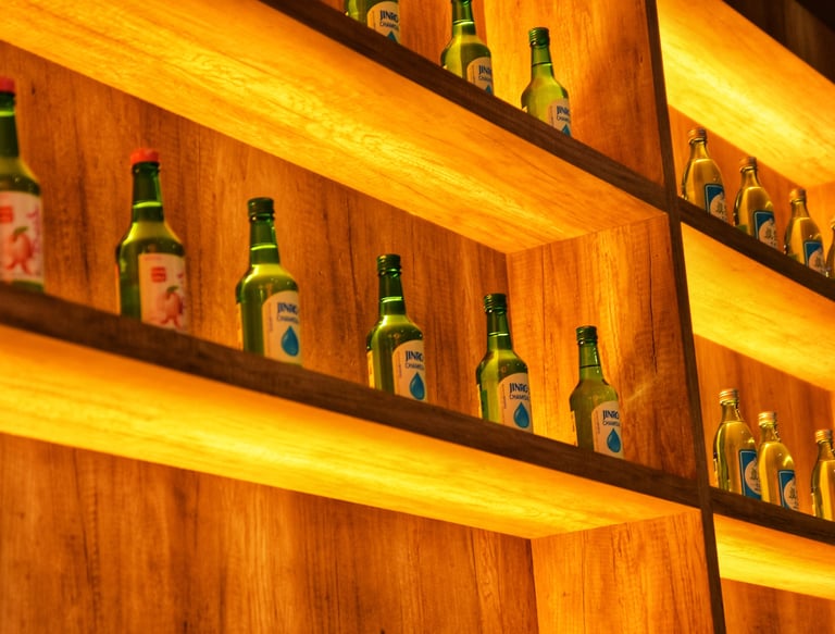 a shelf of bottles of beer and bottles of soju, korean alcohol