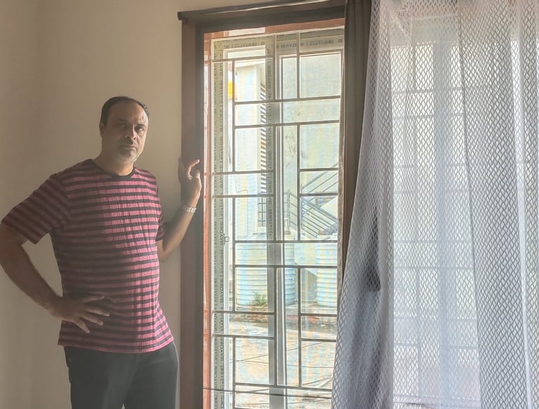 Bright balcony with mosquito nets installed on doors and windows, sunlight filtering through.