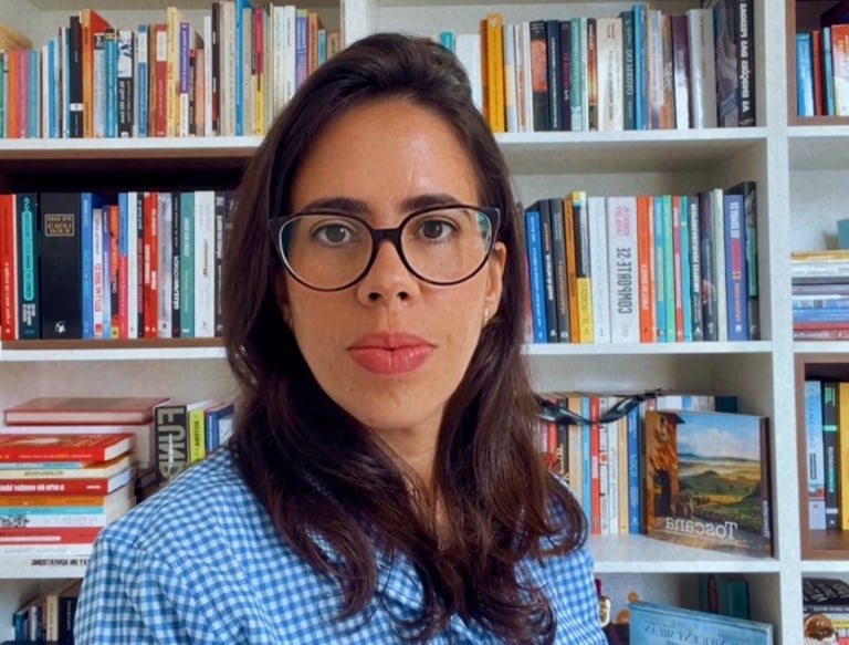 a woman in a blue shirt and glasses in your library