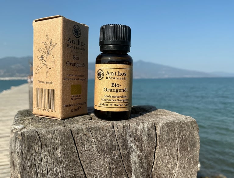 a bottle of orange essential oil sitting on a wooden post