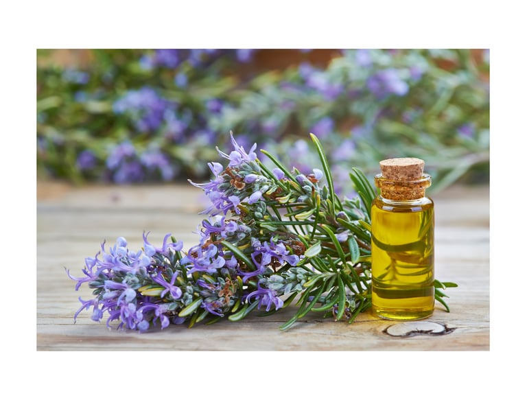 a bottle of essential oils with a bunch of flowers