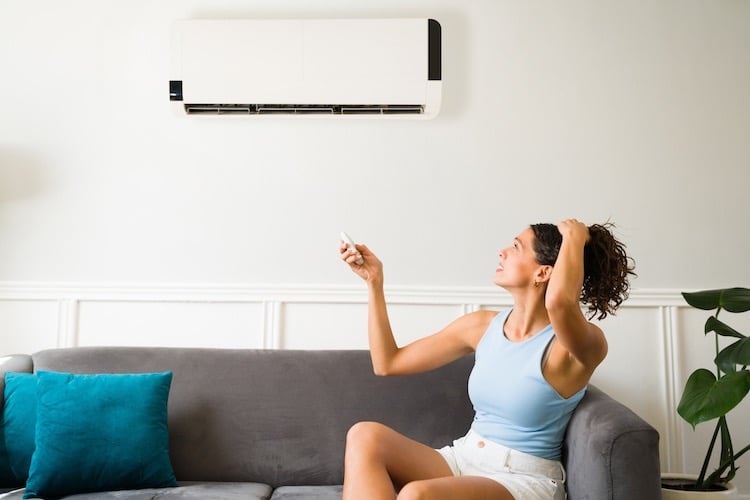 a woman sitting on a couch with a remote control