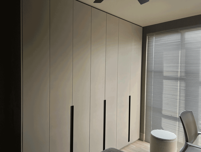 Closet moderno gris con persianas horizontales en recámara iluminada | KARÄNA