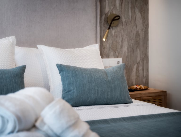 Una cama con una manta y almohadas encima