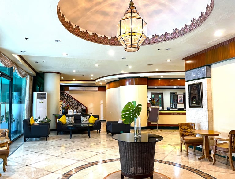 a lobby area with a large circular table and chairs