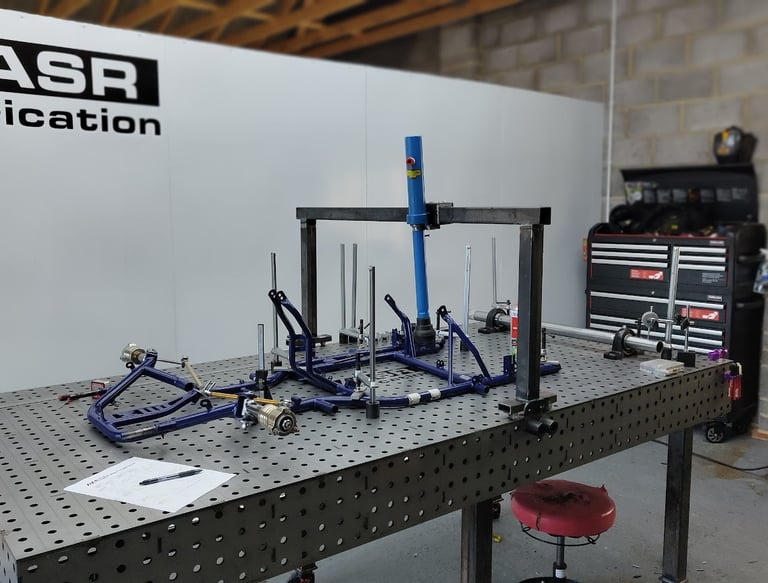 a table with a bunch of tools and kart frame on it