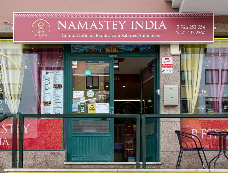 Exterior storefront of Namastey India, an authentic Indian restaurant with menu and outdoor seating.