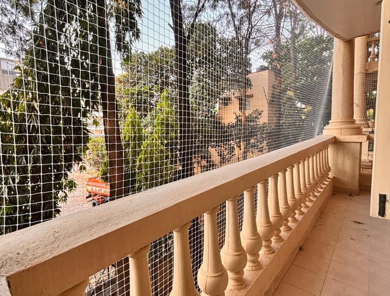 Wide shot of a residential building with multiple balconies fitted with clean, well-maintained pigeo