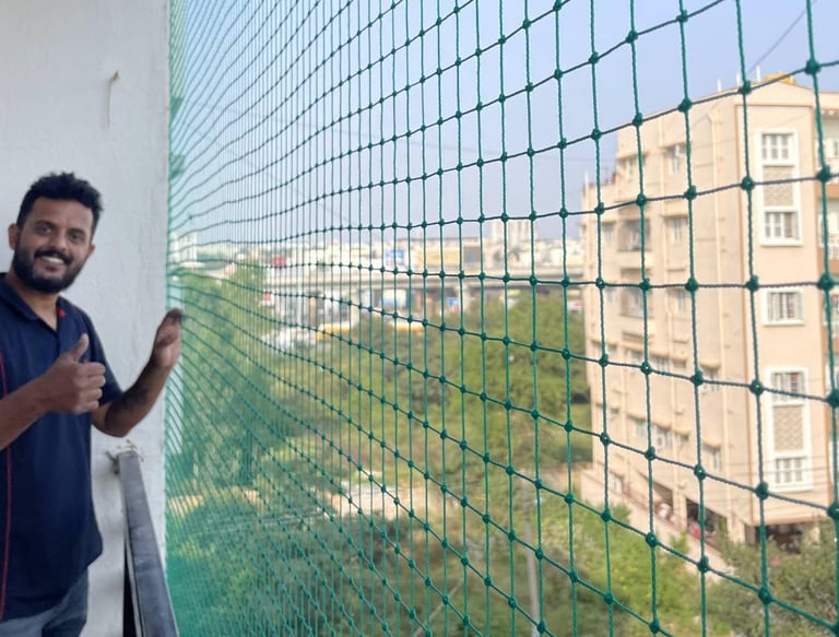 Happy family standing safely behind a newly installed balcony safety net in Anna Nagar.