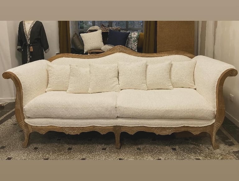 modernisation d'un canapé classique en remplaçant le tissu velours rouge par un tissu bouclette écru