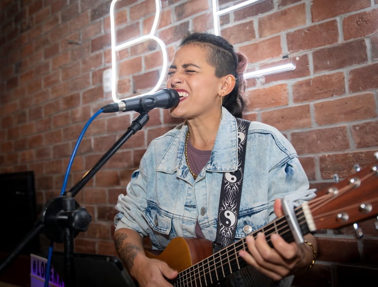 Lorena Uría cantando en formato solista, voz y guitarra, en un bar de Miraflores, Lima, Perú.
